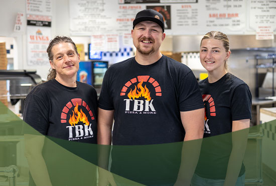 Small Business Loan photo: three pizza restaurant workers, smiling at the camera.